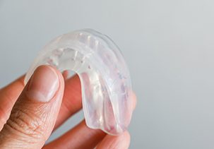 Patient holding clear mouthguard