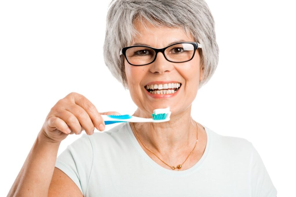 A woman brushing her dental implants